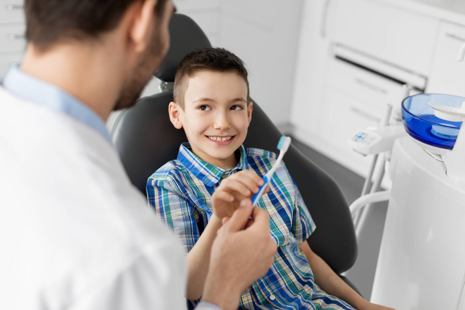 SD Dentist giving young patient a toothbrush