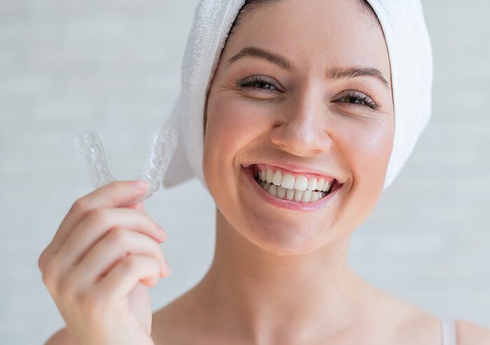 SD Woman smiling and holding Oral Appliance